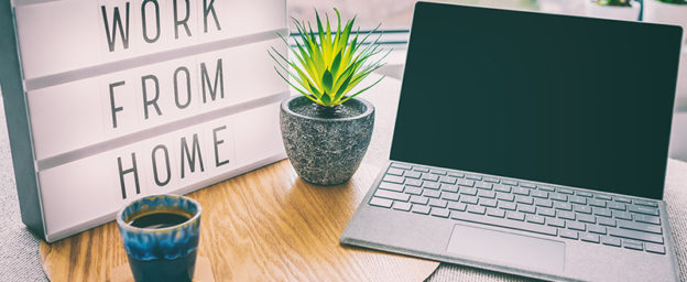 work from home sign with laptop, coffee cup, and plant